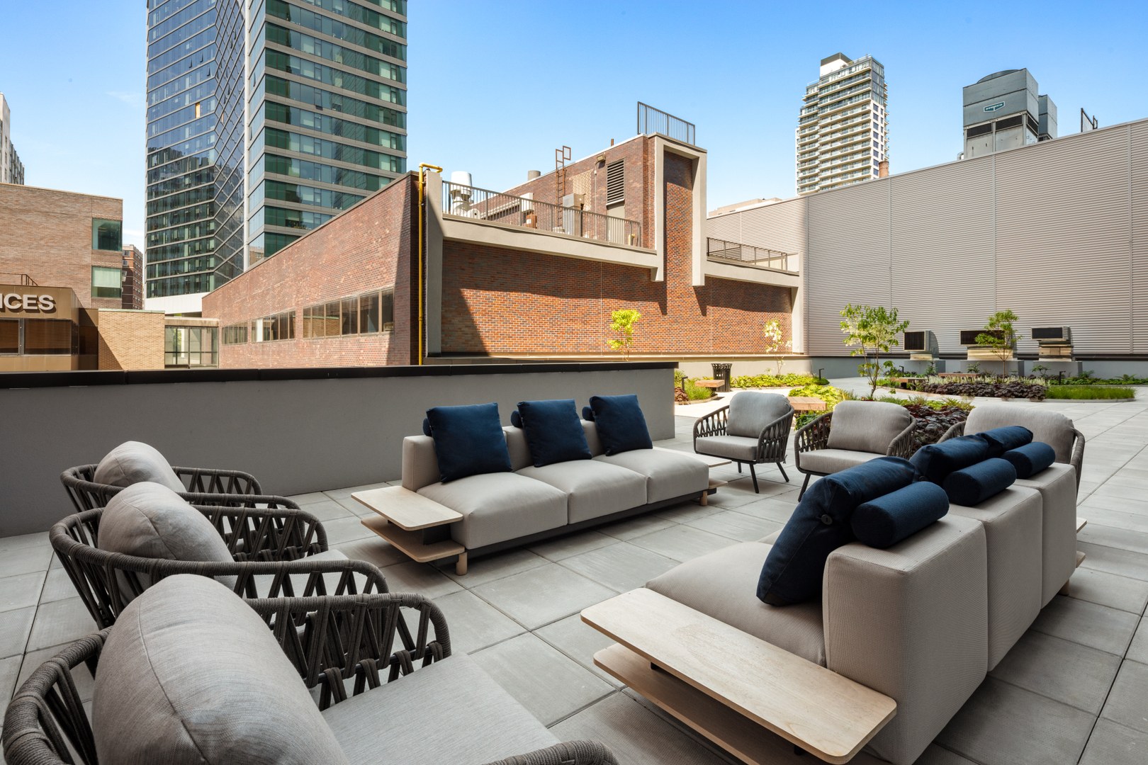 89Dekalb_EXT_Amenities_RooftopTerraceOutdoorSofaLoungersWithCityView